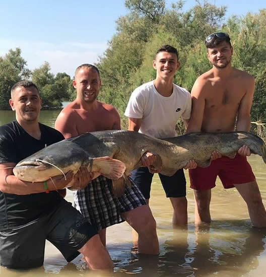 Manchester City star Phil Foden catches gigantic catfish during fishing trip in Spain