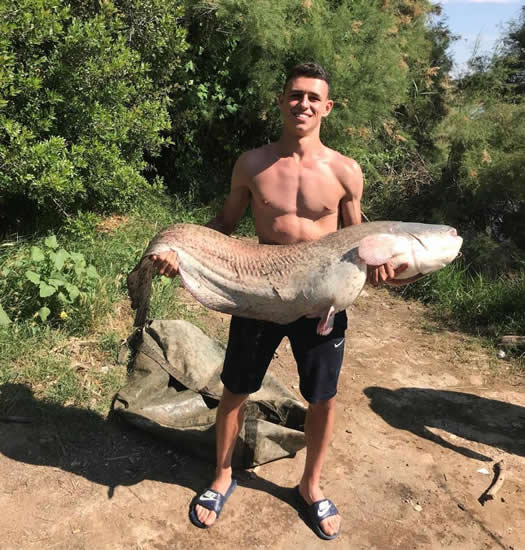 Manchester City star Phil Foden catches gigantic catfish during fishing trip in Spain