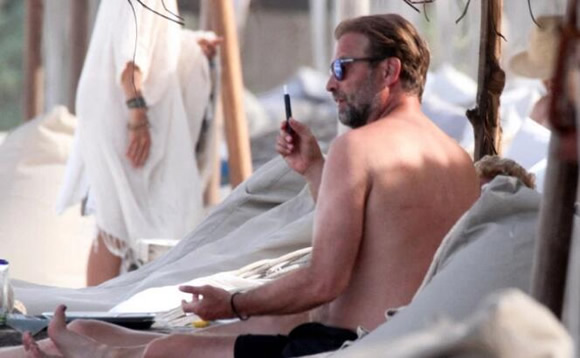 Jurgen Klopp vapes on beach as wife smokes and struggles to keep tiny bikini on in sea while Liverpool boss supports Red Sox with hat
