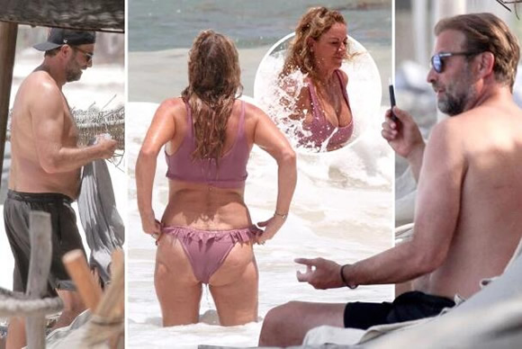 Jurgen Klopp vapes on beach as wife smokes and struggles to keep tiny bikini on in sea while Liverpool boss supports Red Sox with hat