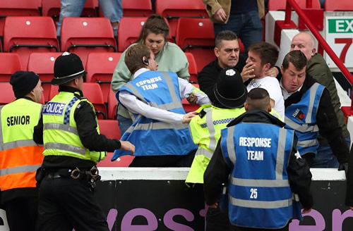 Punches thrown as Leeds and Barnsley fans fight in stadium before security drag thug away in headlock