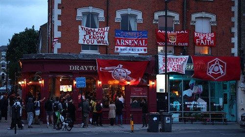 Let the party begin! Arsenal fans descend on Emirates Stadium for wild Premier League title celebrations featuring flags and flares
