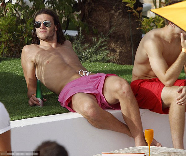 Euro who? England player Andy Carroll lets his hair down and surrounds himself with strikers (of the female variety) in Ibiza