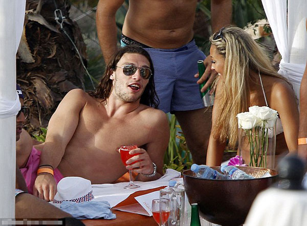 Euro who? England player Andy Carroll lets his hair down and surrounds himself with strikers (of the female variety) in Ibiza