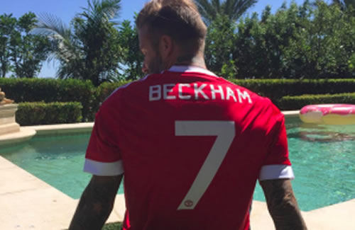 David Beckham models a new Man United home shirt which fans are banned from buying at the club store