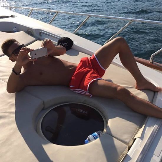 Mesut Ozil sunbathes on a boat ahead of Arsenal v Man City