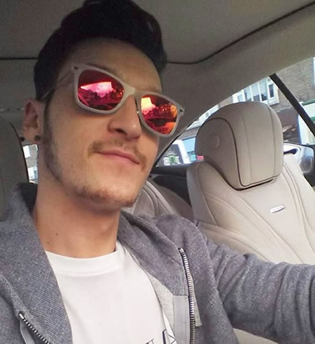 Mesut Ozil drives home from Arsenal training in upbeat mood