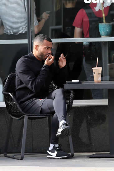 Ashley Cole ignores doctors' warnings as he uses tobacco snus outside LA coffee shop while with Italian model girlfriend