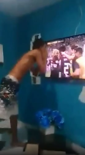 Outrage as Brazilian football fan swings son by the ankles while celebrating goal