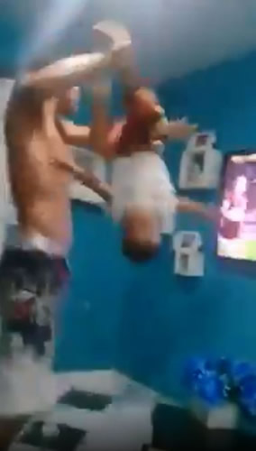 Outrage as Brazilian football fan swings son by the ankles while celebrating goal