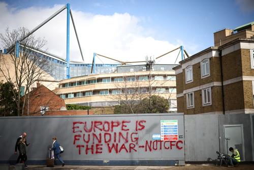Workers paint over graffiti outside Stamford Bridge after fuming Chelsea fans deface hoardings
